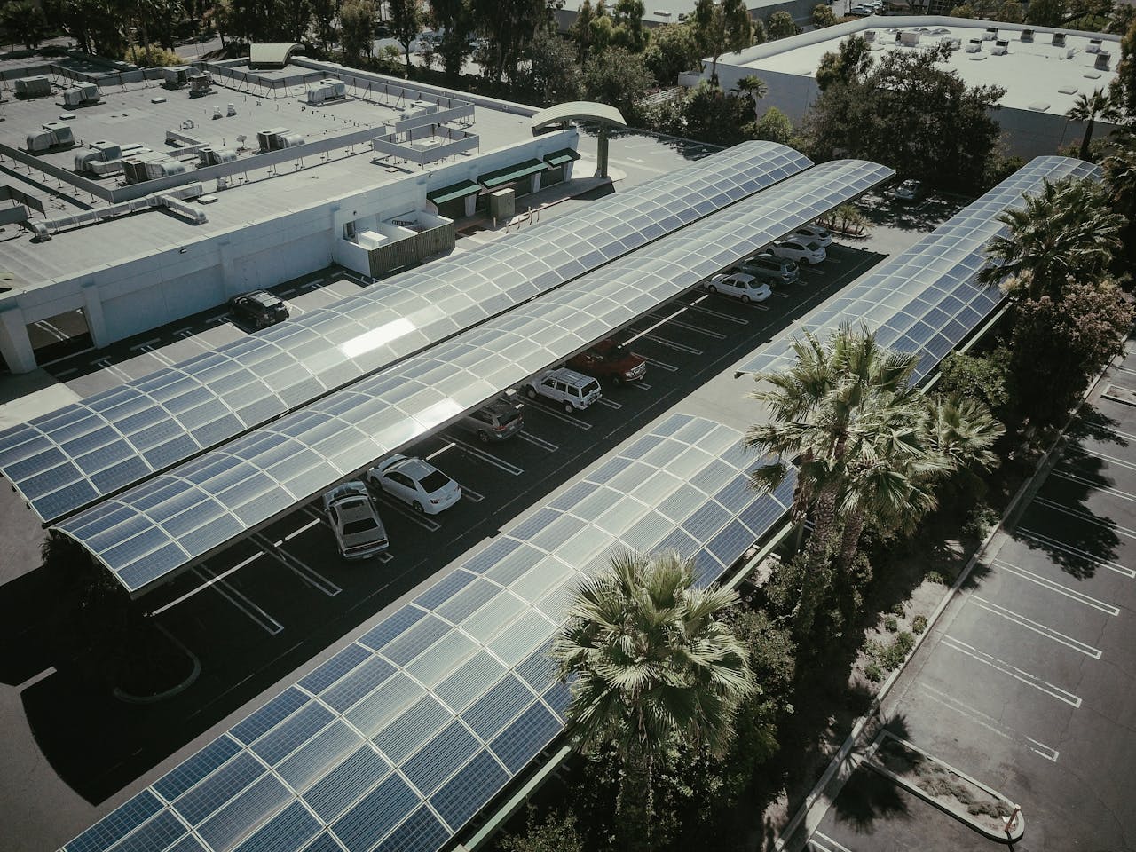 Home Aerial view of a parking lot with solar panel canopies, showcasing clean energy usage.