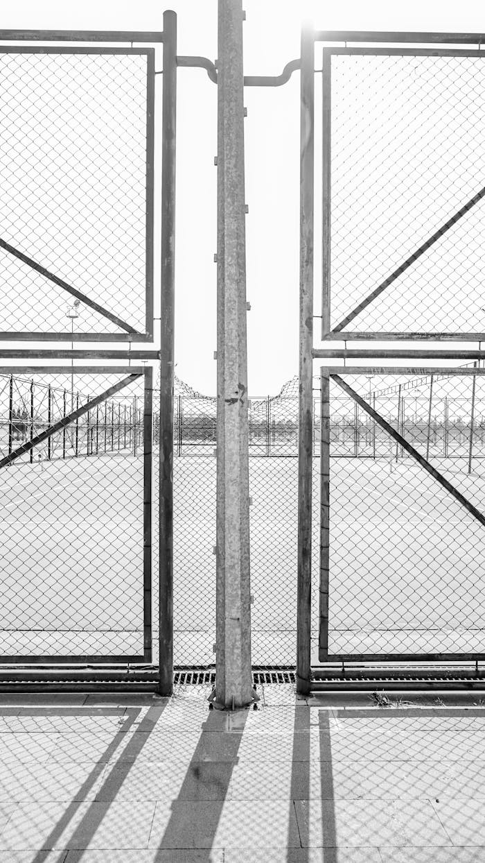 Home Monochrome view of a tennis court gate with wire mesh in Kayseri, Türkiye.